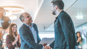 HDN Chair Debansu Das shaking hands with a member