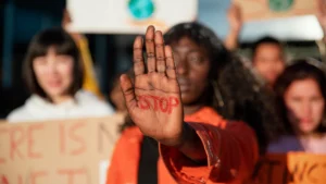 Stock image: a young black women with stop written on her hand in red.