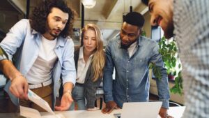 Stock image: People gathering around to look at a document