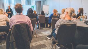 A group of people sat watching a presentation(eye-candy)